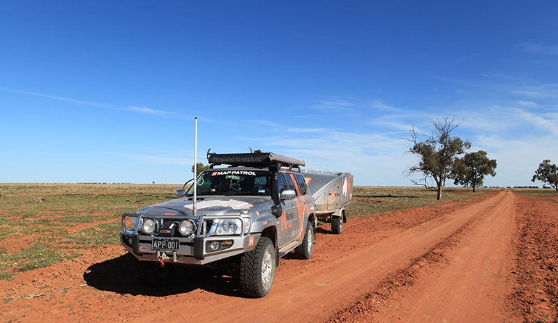 a dusty 4x4 vehicle on a red dirt track in the Australian outback